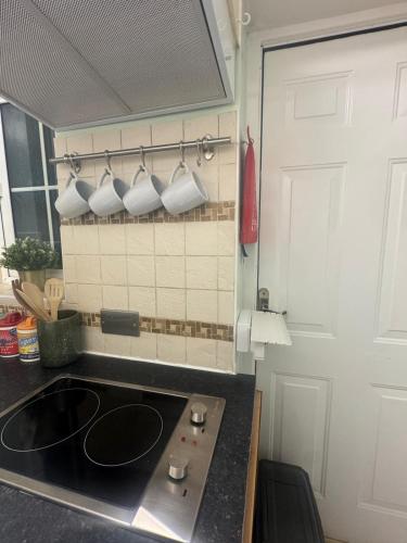 a kitchen with a sink and some cups on a rack at Bedsit Birmingham in Oldbury
