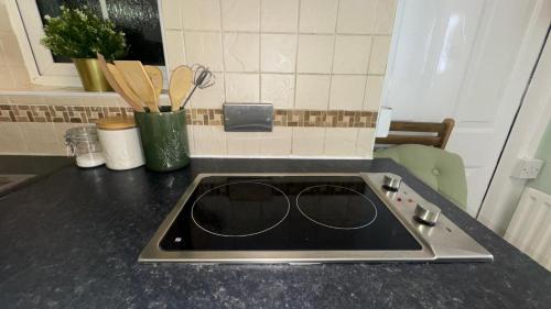 a kitchen counter with a sink with sunglasses on it at Bedsit Birmingham in Oldbury