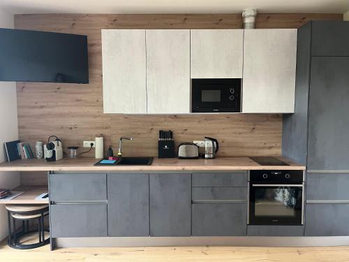a kitchen with white cabinets and a counter top at MOAD apartmán v srdci Šumavy in Železná Ruda