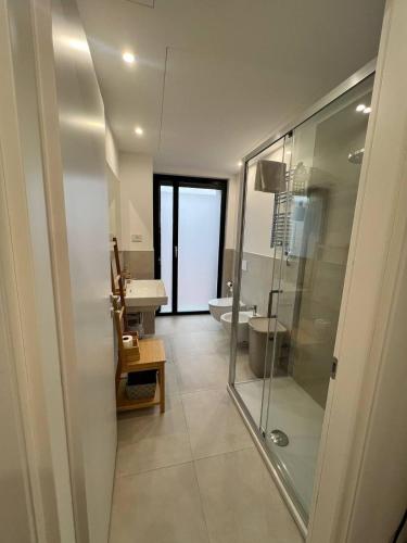 a bathroom with a glass shower and a sink at LikeHome PortaReno Monolocale Exclusive - 4 pxs in Ferrara
