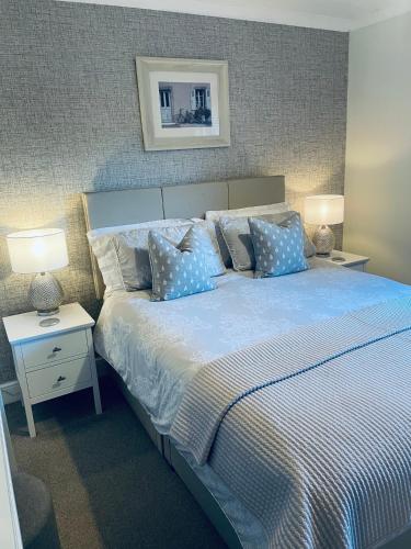 a bedroom with a large bed with blue pillows at Apartment 101 Kingsmills Road in Inverness