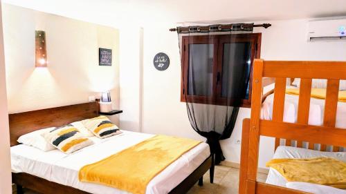 a bedroom with two beds and a television in it at Auberge de Cannedda in Sari Solenzara