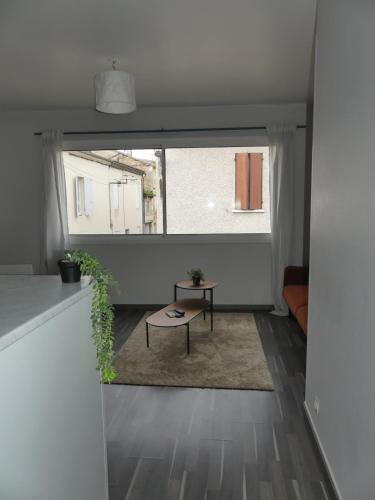 a living room with a large window and a table at Evasion Parfaite ! Proche Gare et Clim in Marmande