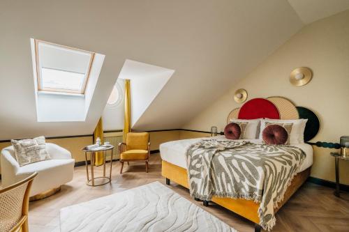 a attic bedroom with a bed and a chair at Colette - LoftAffair Collection in Warsaw