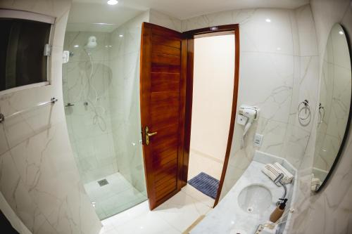 a bathroom with a shower and a toilet and a sink at Paraíso das Dunas in Natal