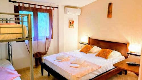 a bedroom with a bed with towels on it at Auberge de Cannedda in Sari Solenzara