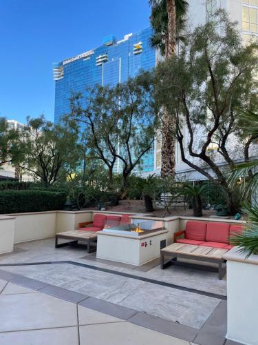 a patio with couches and trees and a building at MGM SIGNATURE - Strip View Suite- FREE valet parking in Las Vegas