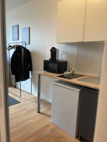 - une cuisine avec un comptoir, un four micro-ondes et une table dans l'établissement Studio Hôtel Villeurbanne Centre, à Villeurbanne
