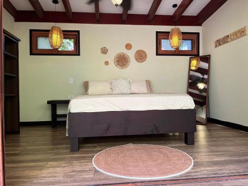 a bedroom with a bed and a table and windows at Playa Bluff Lodge in Bocas del Toro