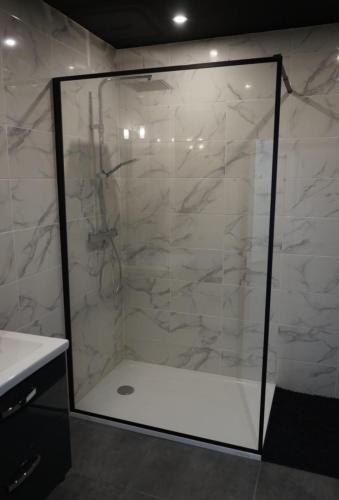 une douche avec une porte vitrée dans une salle de bain dans l'établissement Séjour détente, maison SPA-Sauna, à LʼHôpital