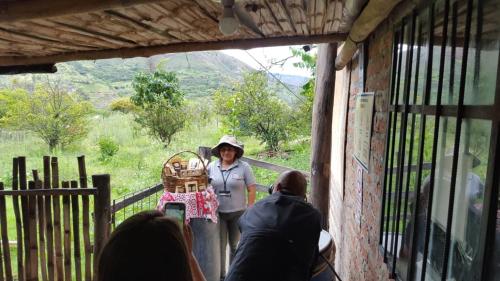 a woman standing in a doorway with a motorcycle at Hacienda Gonzabal in Loja