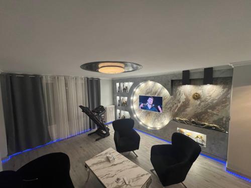 un salon avec des chaises noires et un tableau au mur dans l'établissement Appartement neuve avec jacuzzi, à Orléans