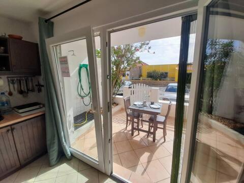 an open door to a patio with a table and chairs at Studio Murdeira Side Beach, Eco Protected Bay, Pool 161B in Beirona