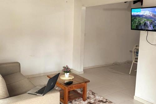 a living room with a couch and a laptop on a table at Casa en el centro de Pilar, Ñeembucú in Pilar