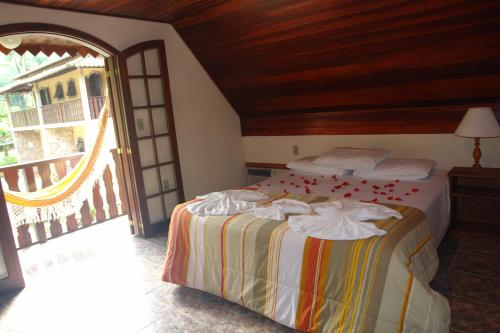 a bedroom with a bed and a balcony at Pousada Solar das Montanhas in Penedo