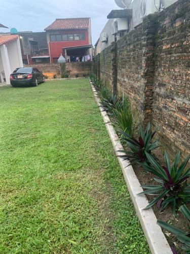 a yard next to a brick wall with plants at Casa en el centro de Pilar, Ñeembucú in Pilar
