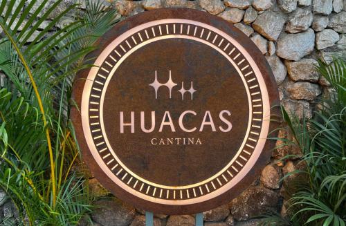 a sign that says hucas cantina on a stone wall at The Beach Break Hotel and Surf Club by Tierra Magnifica in Nosara