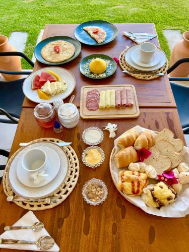 a wooden table with plates of food on it at Yahweh Hotel in São Miguel do Gostoso