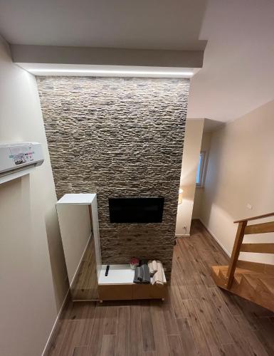 a living room with a brick fireplace with a tv at Al Capannone di Pietro in Colli al Volturno