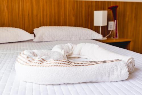 a bed with two white towels on top of it at Paraíso das Dunas in Natal