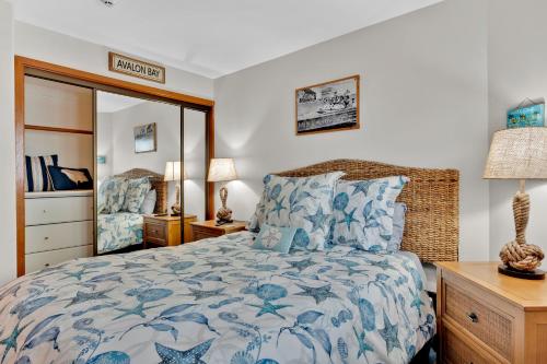 a bedroom with a blue and white bed and a mirror at Ocean View Hamilton Cove Villa in Avalon