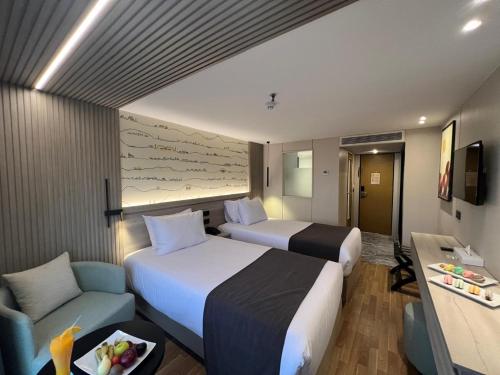 a hotel room with two beds and a couch at Nile Cruise 5 Stars From Luxor And Aswan 3&4 Nights in Aḑ Ḑab‘īyah