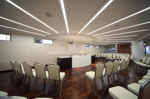 uma sala de conferências com cadeiras e um pódio no meio em E' Hotel em Reggio di Calabria
