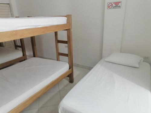 two bunk beds in a room with a sign on the wall at Hostal Arrecifes in Necoclí