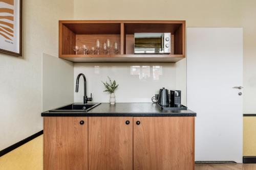 a kitchen with a sink and a microwave at Colette - LoftAffair Collection in Warsaw