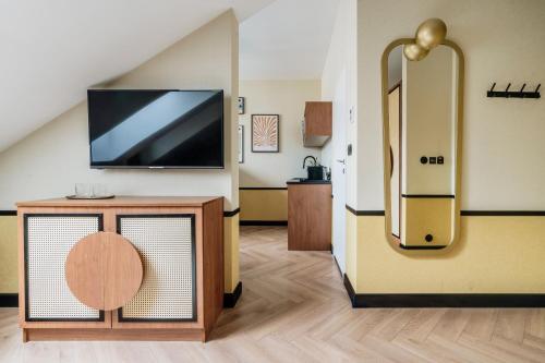 a living room with a tv and a refrigerator at Colette - LoftAffair Collection in Warsaw