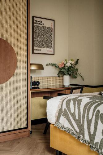 a bedroom with a bed and a desk with flowers at Colette - LoftAffair Collection in Warsaw