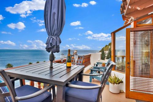 a table and chairs on a balcony with a view of the ocean at Ocean View Hamilton Cove Villa in Avalon