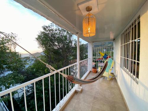 a hammock on the porch of a house at Vito Hotel Boutique Taganga in Taganga
