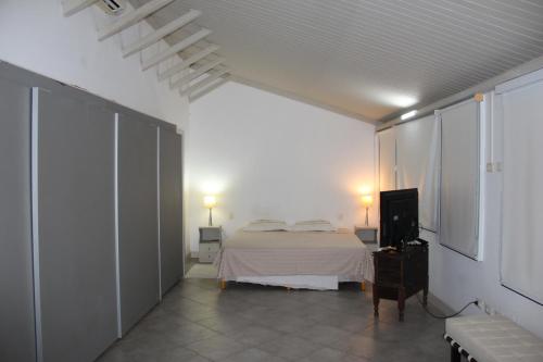 a bedroom with a bed and a tv in it at Ondina Apart Hotel Cobetura in Salvador