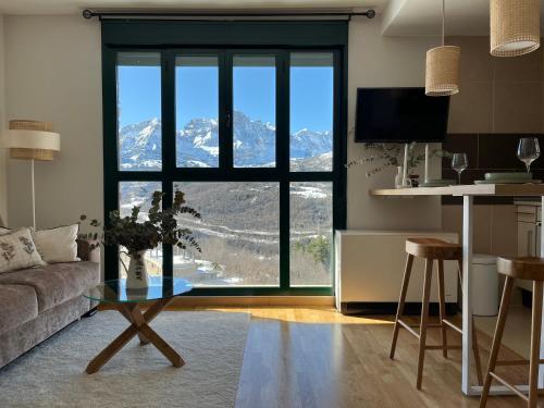 een woonkamer met een groot raam met uitzicht op de bergen bij Snow Hills Panticosa in Panticosa