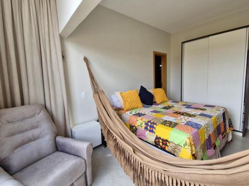 a bedroom with a hammock bed and a chair at Melhor Apartamento de Bananeiras 3 quartos in Bananeiras