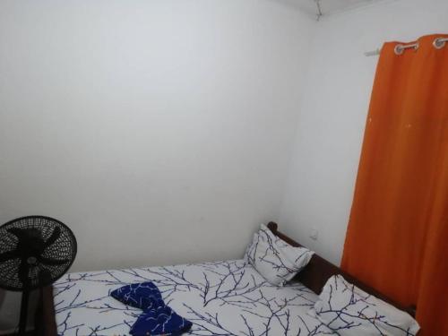 a bedroom with a bed and a fan at Beau séjour by fadilimmo in Yaoundé
