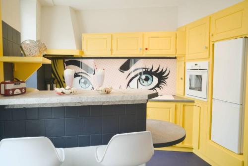 une cuisine avec une peinture murale représentant un œil dans l'établissement Popart Insolite Jacuzzi,Sauna & SPA Parking free, à Mulhouse
