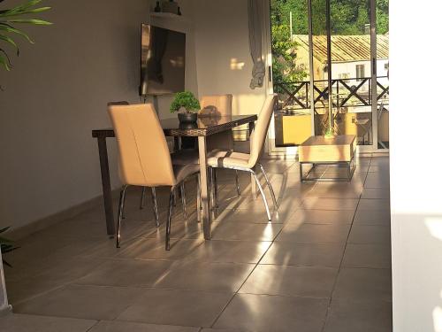 a dining room with a table and chairs on a tile floor at Super appartement T3 proche de tout sans vis-à-vis in Fort-de-France