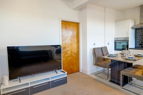 a living room with a large flat screen tv at Zeenat Central Bury - Modern 2BR with Free Parking Sleeps 6 in Bury