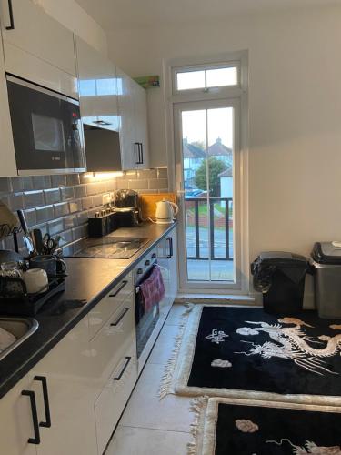 a kitchen with a sink and a stove top oven at Marble House in Edgware
