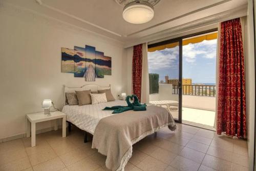 Un dormitorio con una cama y una ventana grande. en Luxury Apartment Costa Adeje, en Playa Fañabe