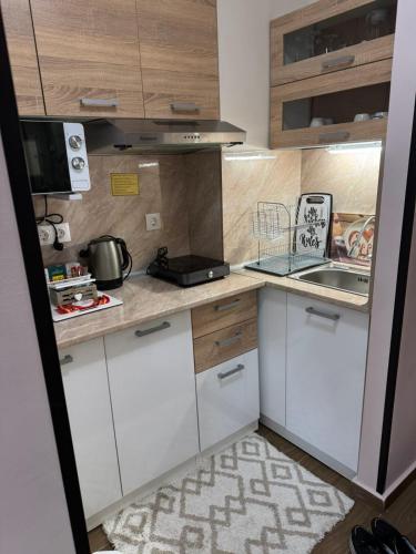 a small kitchen with white cabinets and a kitchen rug at Borovetz Gardens MVS Apart E28 in Borovets
