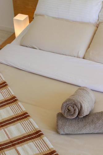 two twin beds with a towel on the bed at Raglan Travellers Rest Coastal Retreat in Raglan