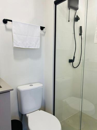 a bathroom with a toilet and a glass shower at LOFT UP 506 | Mobiliado | WIFI | Piscina | Vaga in Blumenau