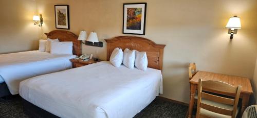 a hotel room with two beds and a desk at Homestead Suites - Fish Creek in Fish Creek