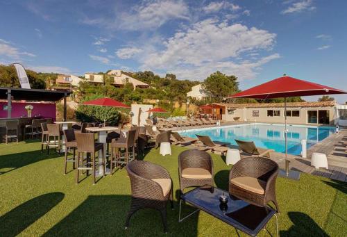un groupe de chaises et une piscine avec une table et des chaises dans l'établissement Villa vue mer exceptionnelle à 500m de la plage de Santa Giulia, à Porto-Vecchio