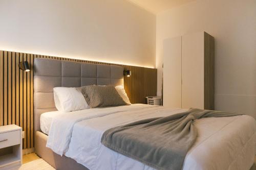 a bedroom with a large bed with white sheets at Central Charm Azores in Ribeira Grande