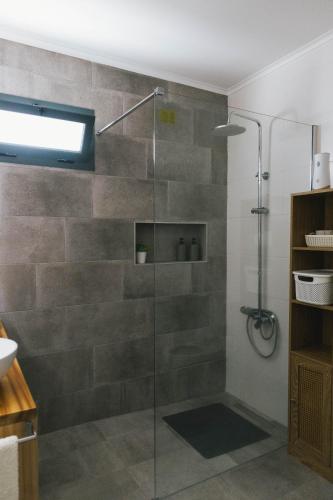 a shower with a glass door in a bathroom at Central Charm Azores in Ribeira Grande