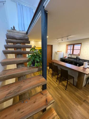 a staircase in a room with a kitchen and a table at Govinda House in Alto Paraíso de Goiás